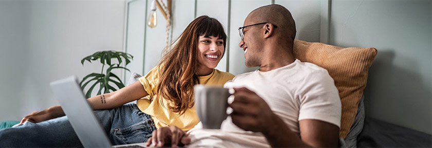 mobile view, couple relaxing indoors with coffee and laptop computer, mortgage blog, Nov 2023, Travis CU,