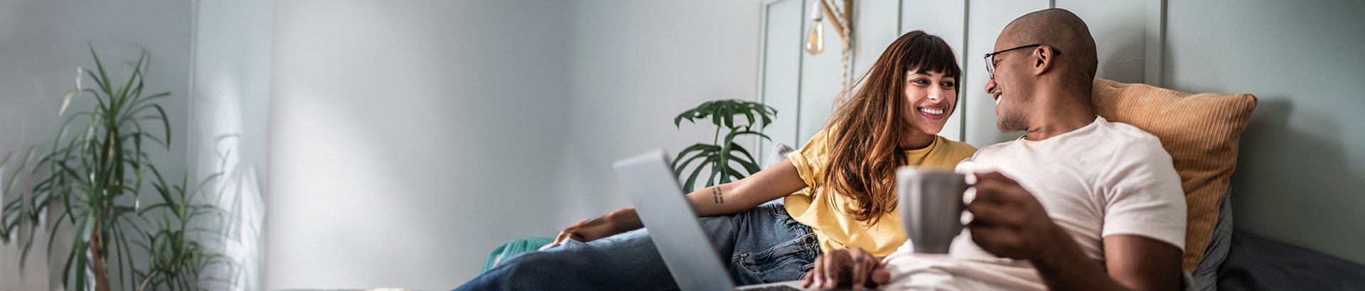 couple relaxing indoors with coffee and laptop computer, mortgage blog, Nov 2023, Travis CU,