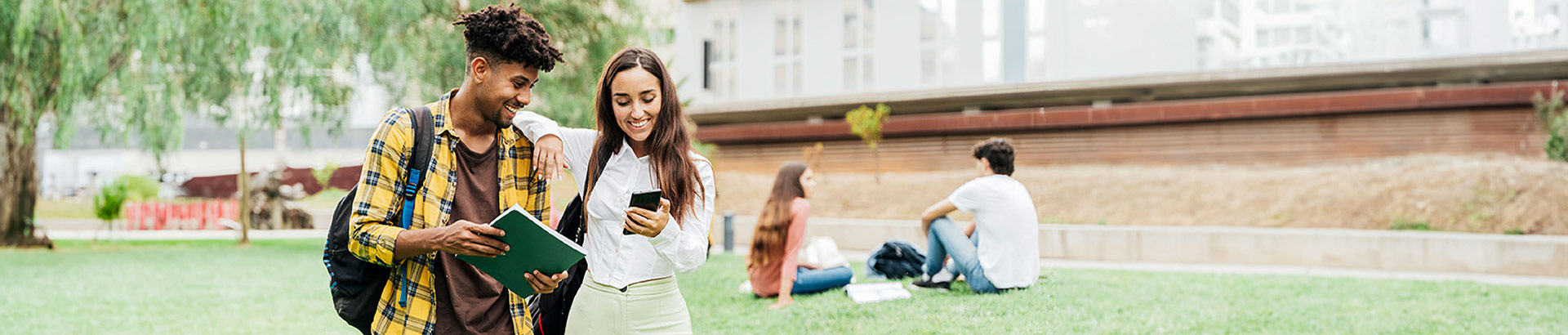 photo of College students lounging outdoors in the quad grass field on campus, Aug 2023 blog, Travis CU