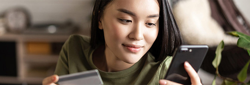 young woman using smartphone for mobile banking, mobile view, Aug2023 blog, Travis CU,