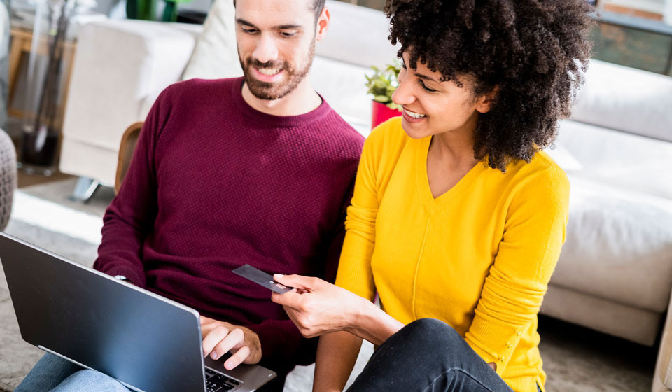 Happy couple purchasing online with a credit card