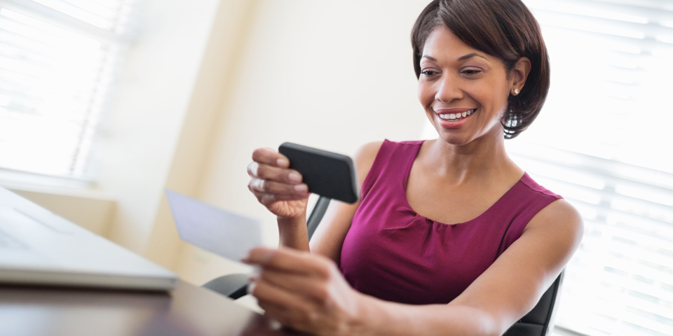 Business woman holding paper check using smart phone Business woman holding paper check using smart phone