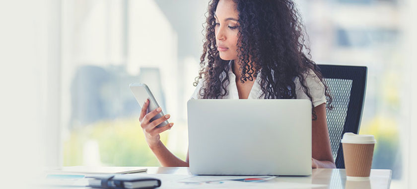 Member feedback, photo of African American woman at office desk with mobile device, mobile view banner, Travis CU,