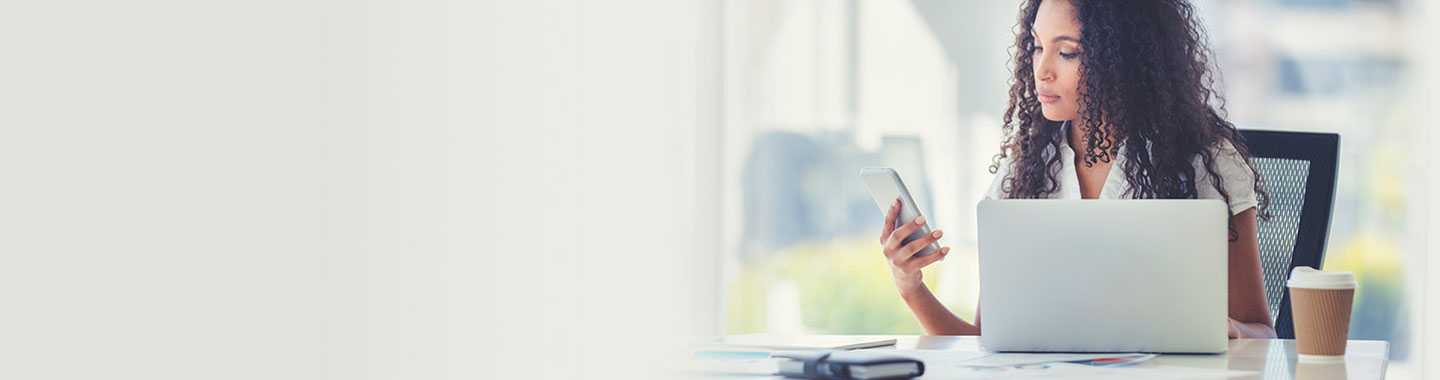 Member feedback, photo of African American woman at office desk with mobile device, photo banner, Travis CU,